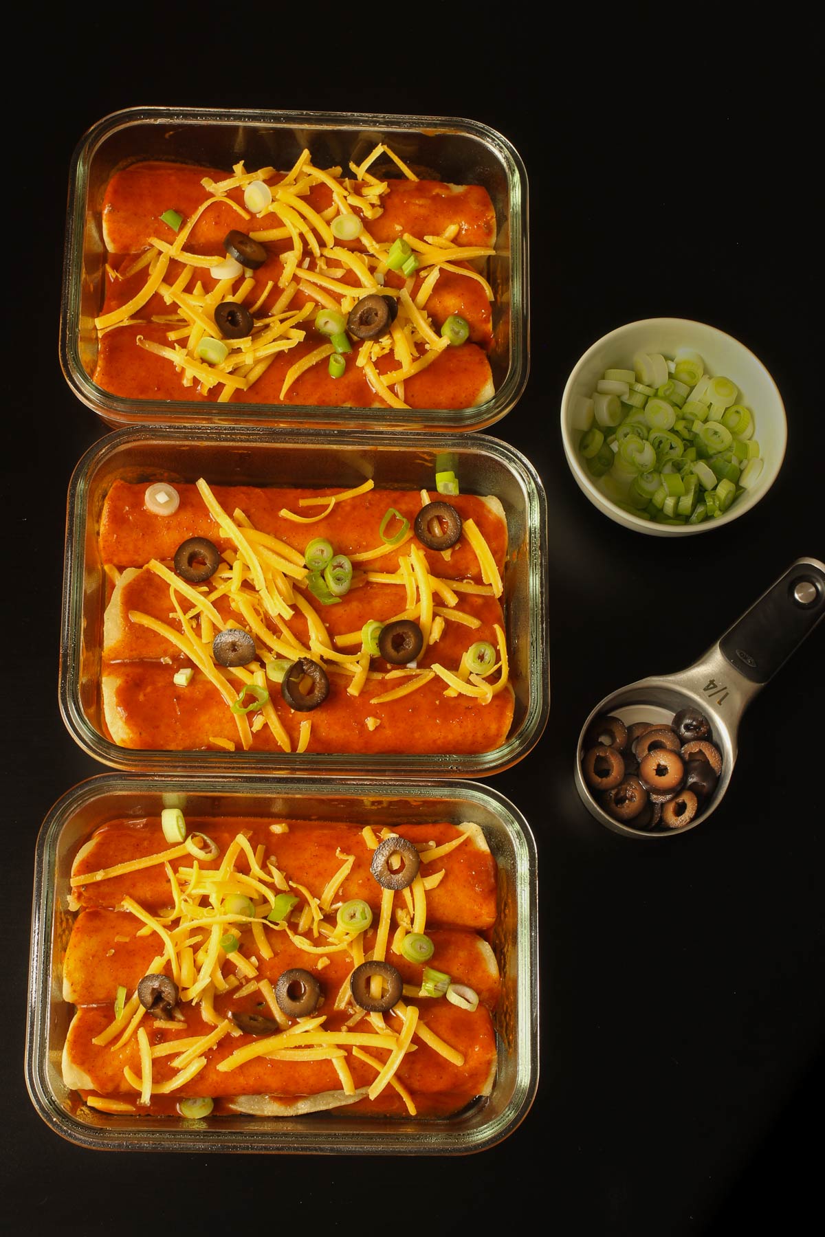 small glass dishes of cheese enchiladas ready to freeze.