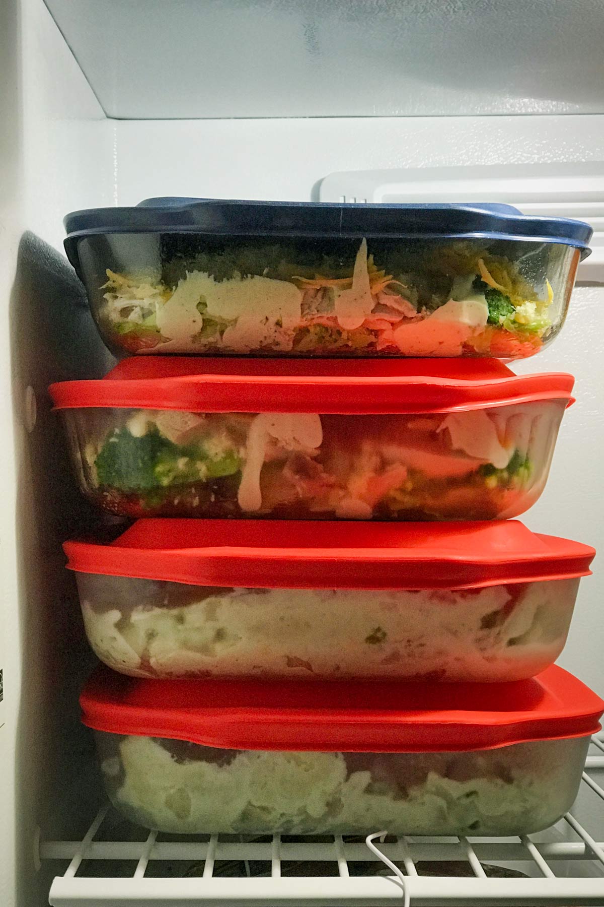 stack of chicken divan in glass casserole dishes in the freezer.