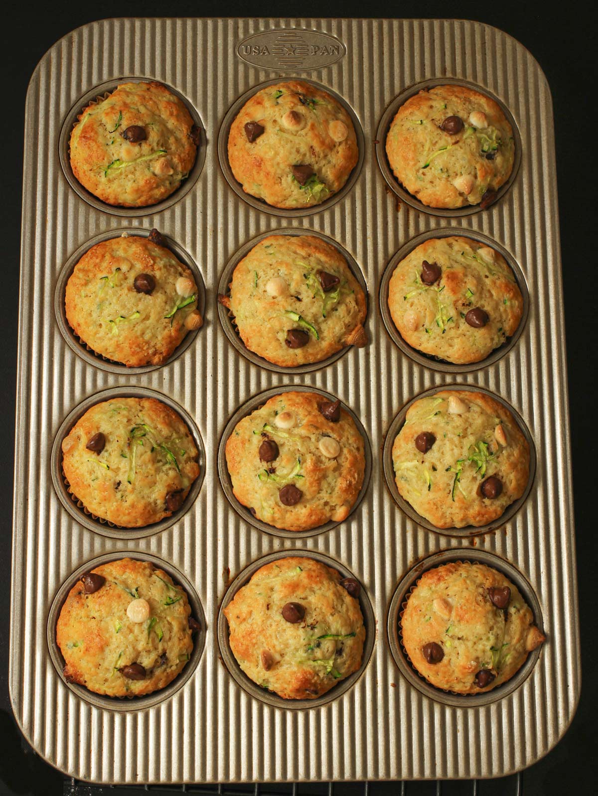 baked chocolate chip zucchini muffins in the muffin pan.