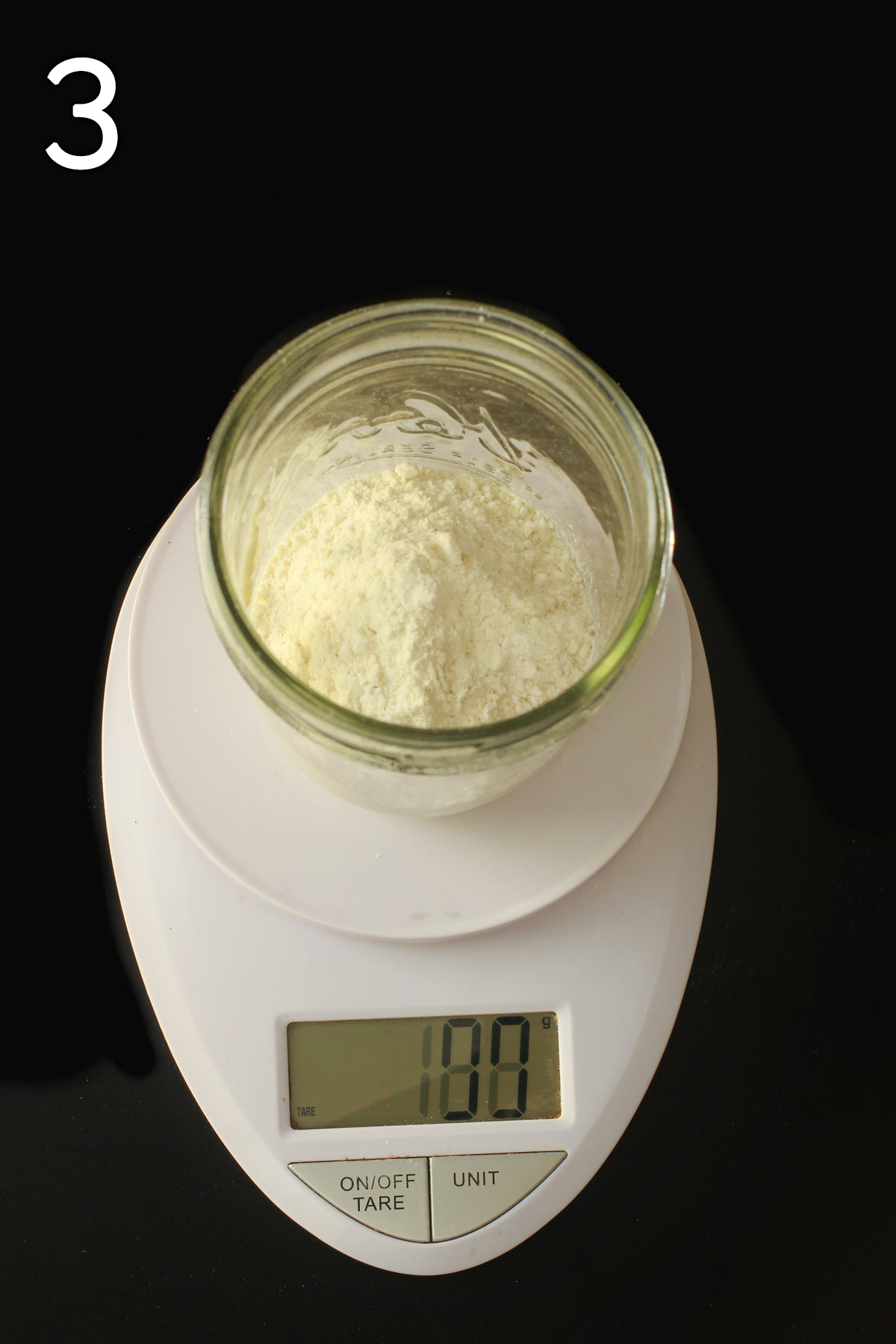 adding 50 grams of flour to sourdough starter on scale.