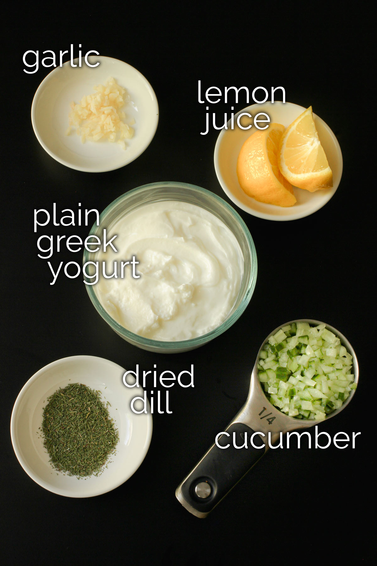 ingredients for garlic yogurt sauce or tzatziki laid out on tabletop.