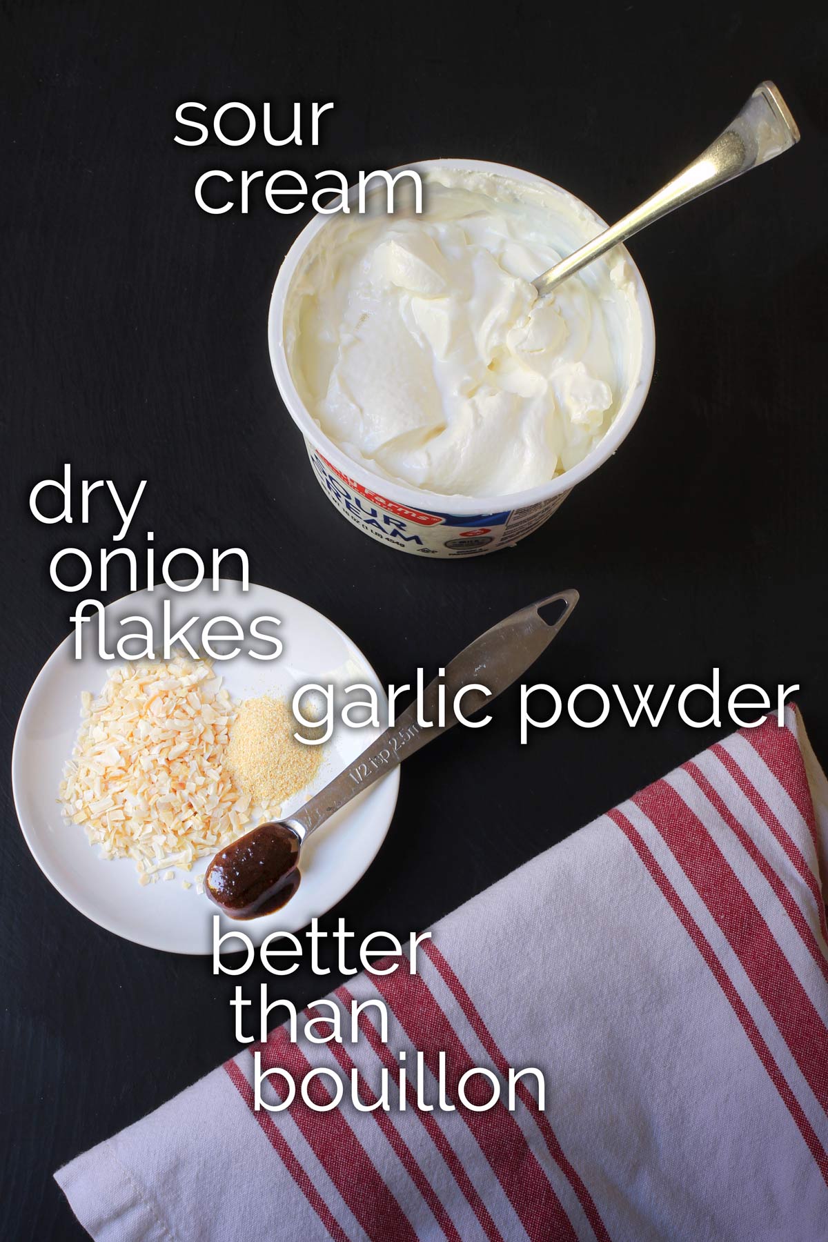 sour cream, onion flakes, garlic powder, and bouillon measured out on table top.