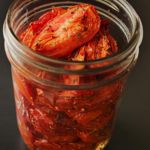 oven roasted tomatoes piled in a mason jar.