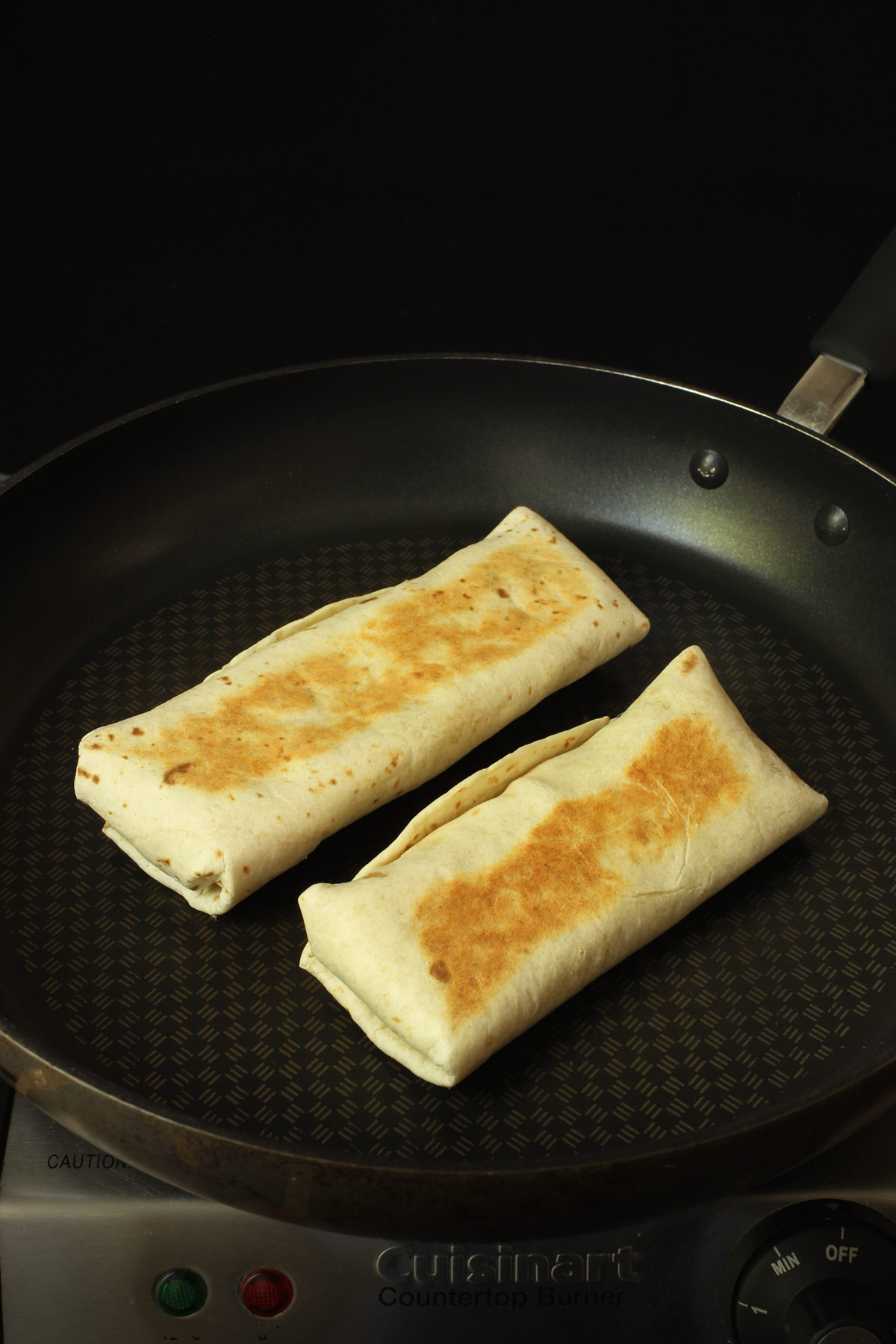 two burritos browned in a dry skillet.