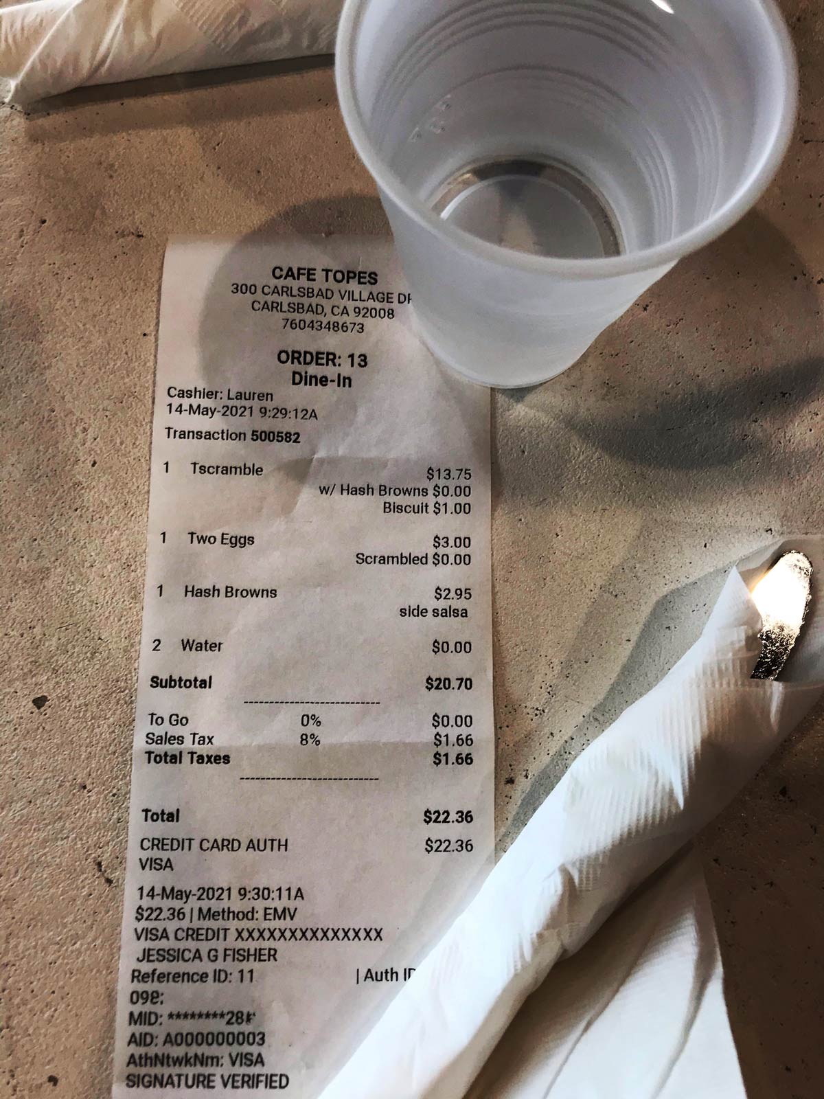 water cup next to receipt listing a la carte items.