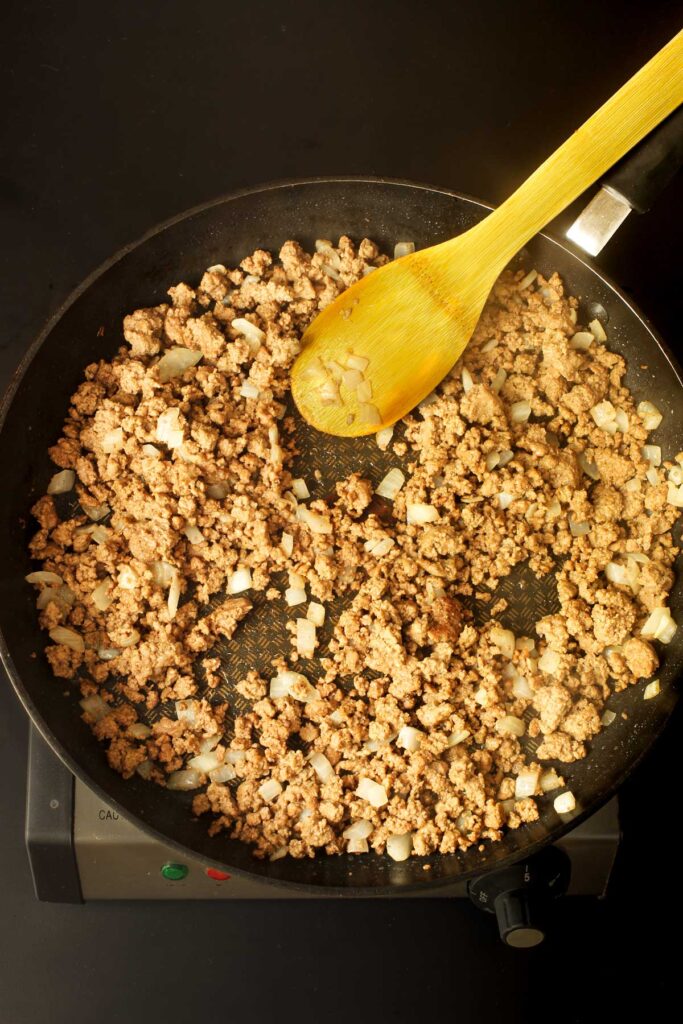 cooked ground beef and onions in skillet.