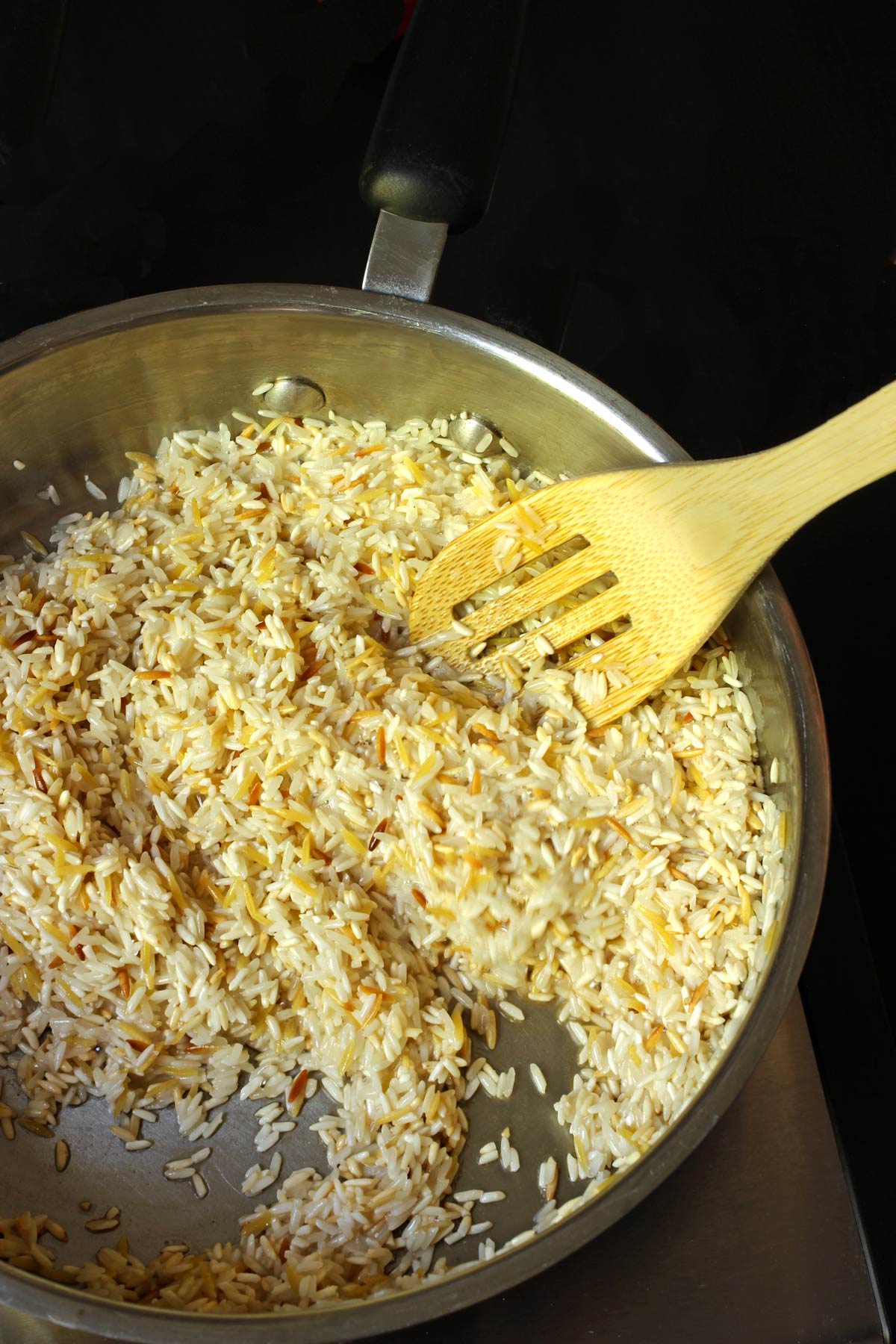 rice and orzo starting to brown in the pan.