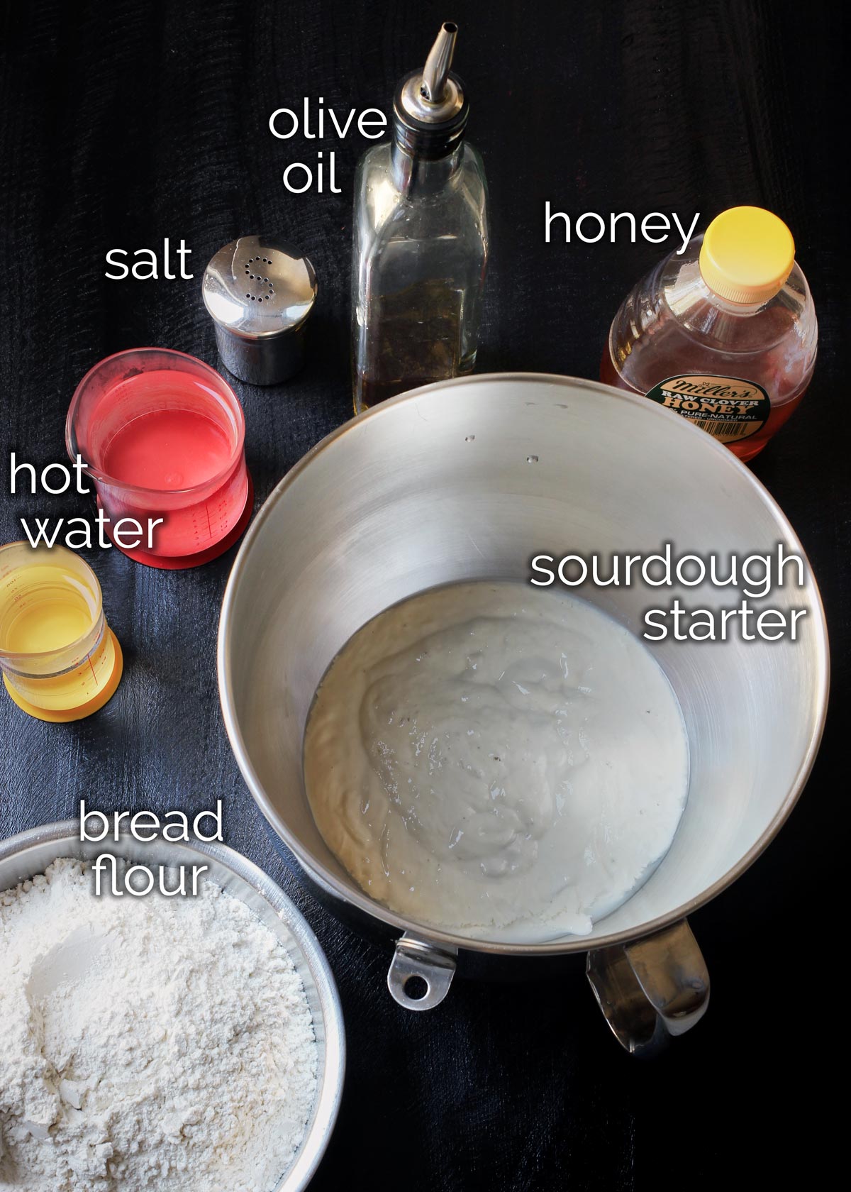ingredients to make homemade sourdough pizza measured out and on work surface.
