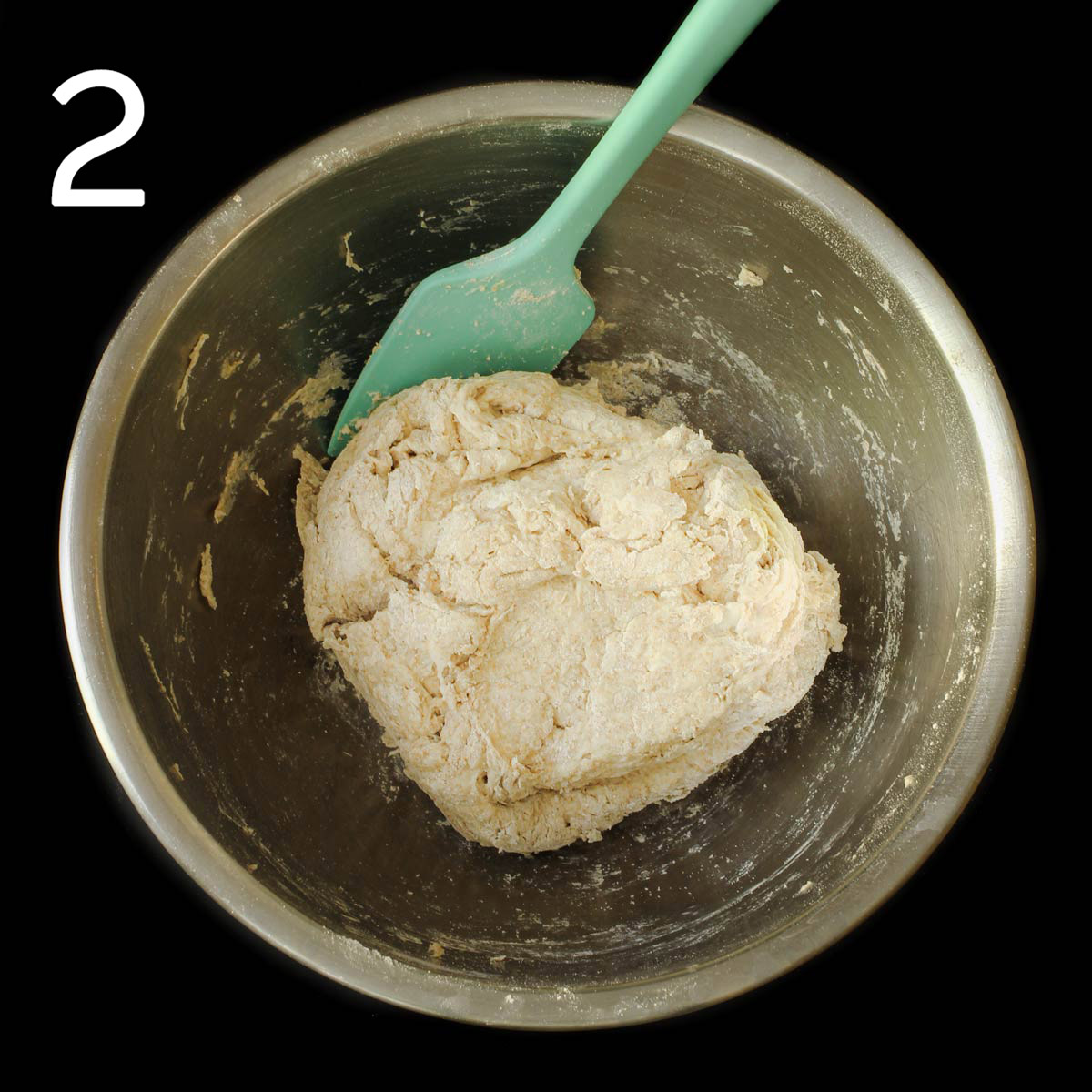 the dough formed with a teal spatula in the mixing bowl.