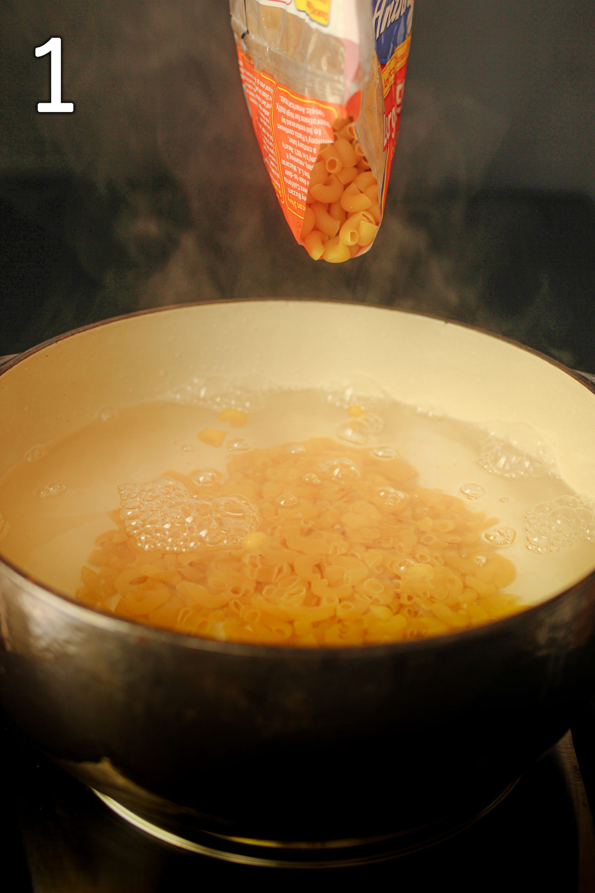 pouring macaroni into a pot of boiling water.