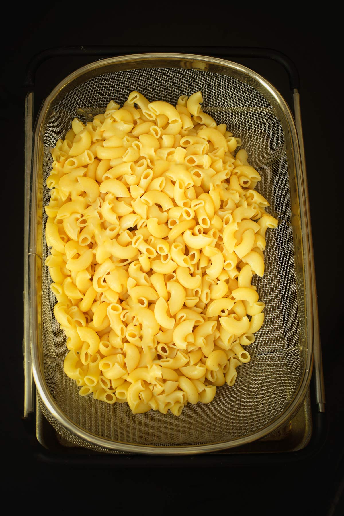 the macaroni draining and cooling in a colander.