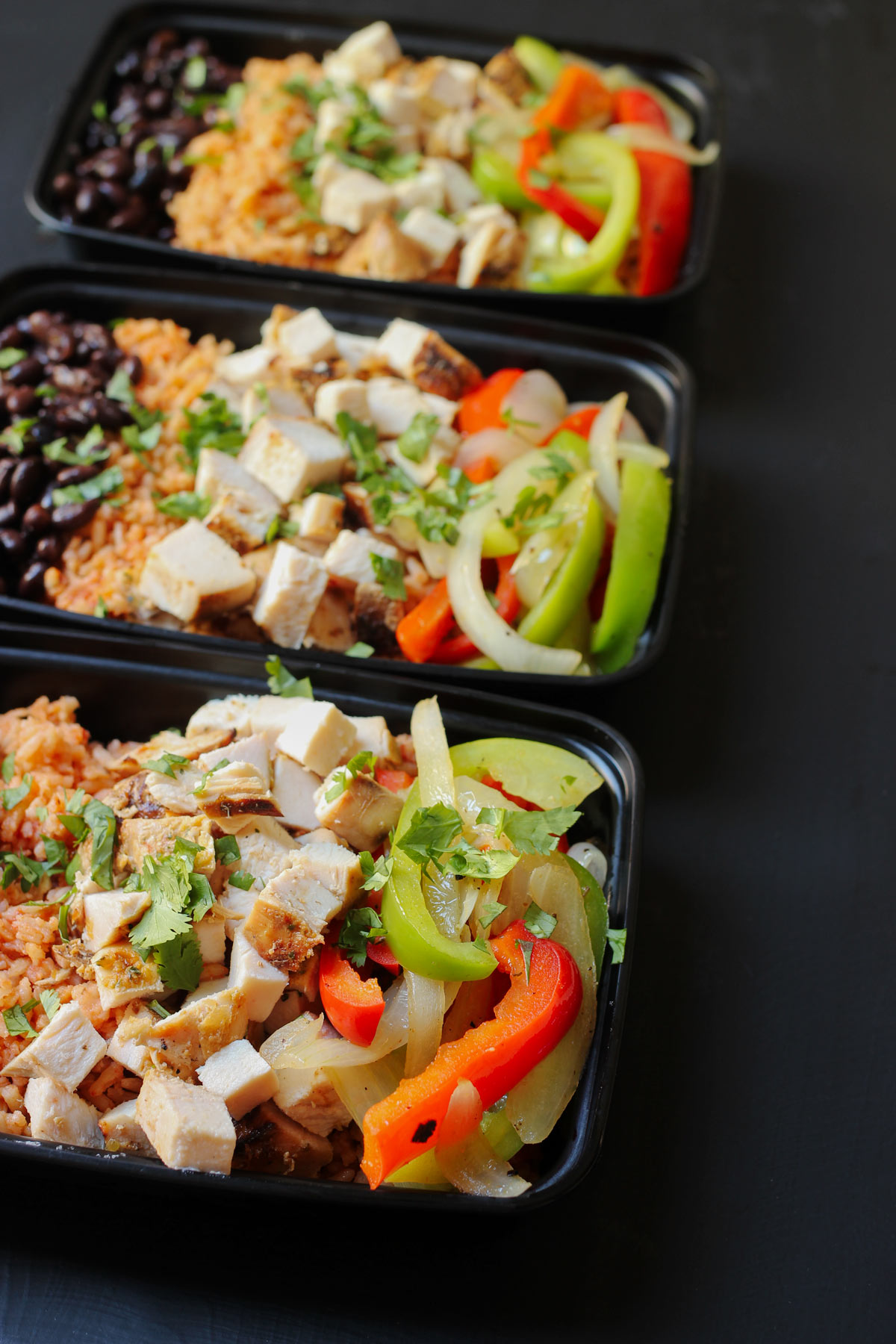 meal prep boxes with fajita burrito bowls assembled.