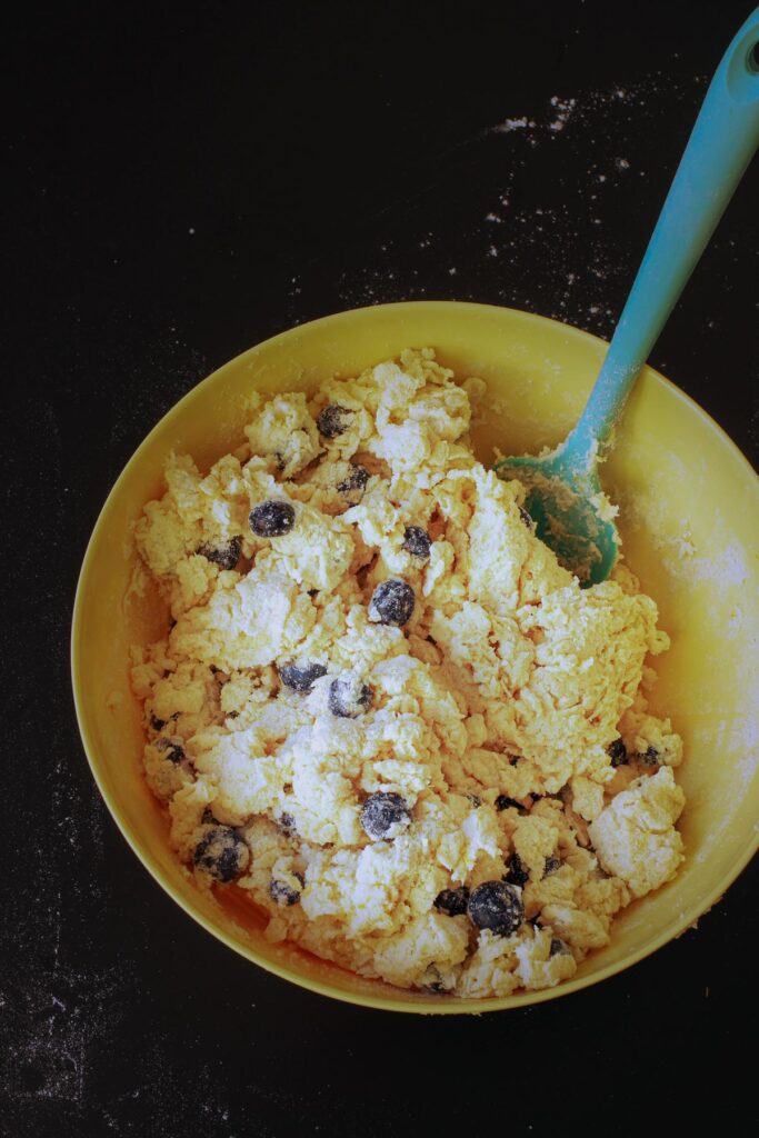 the shaggy dough with blueberries in yellow mixing bowl.