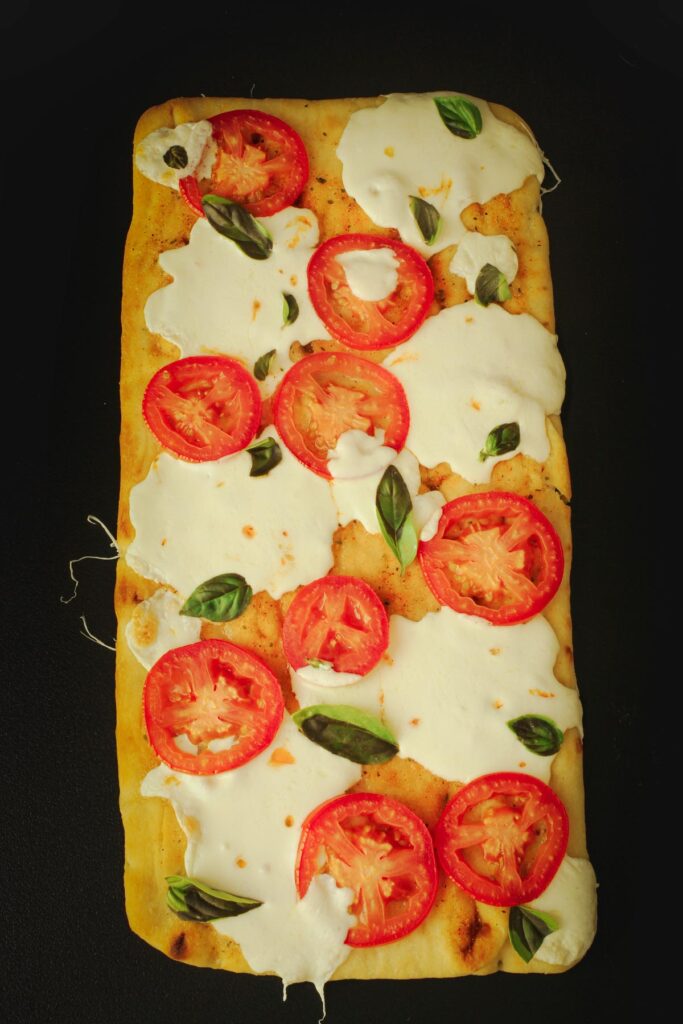the baked flatbread topped with tiny fresh basil leaves.