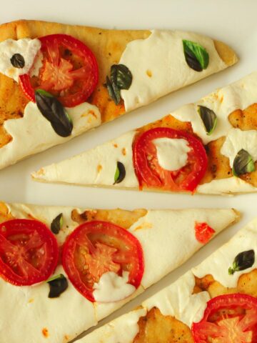 margherita flatbread pizza cut into wedges on a platter.