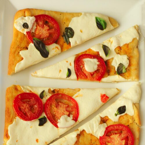 margherita flatbread pizza cut into wedges on a platter.