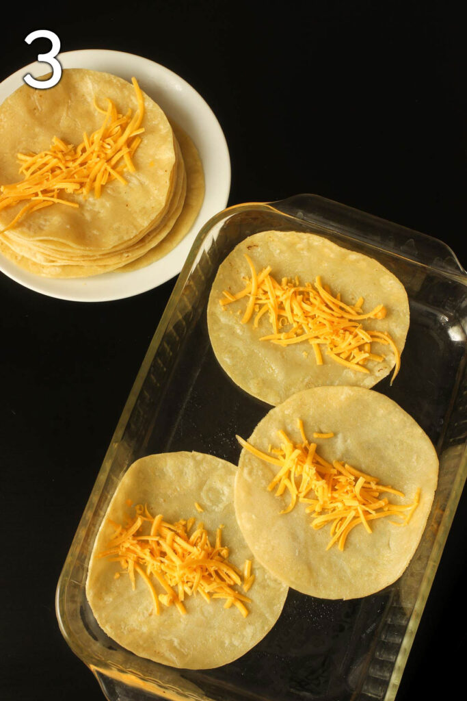 tortillas laid out on baking dish and plate with cheese lined up in the middle.