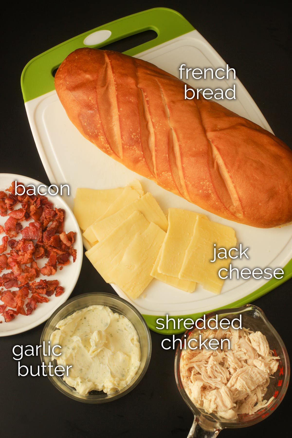 ingredients for hot chicken sandwiches laid out on black tabletop.