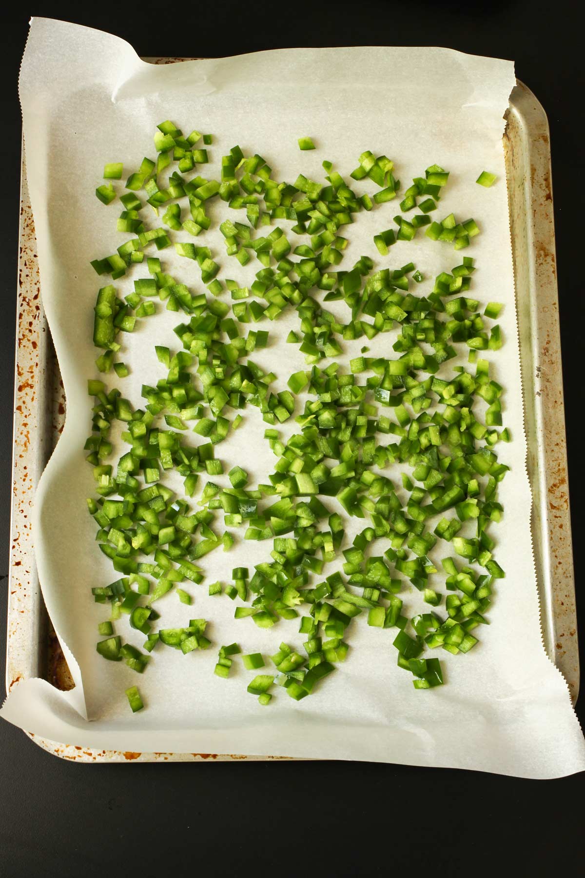 chopped jalapeños on a parchment-lined tray.