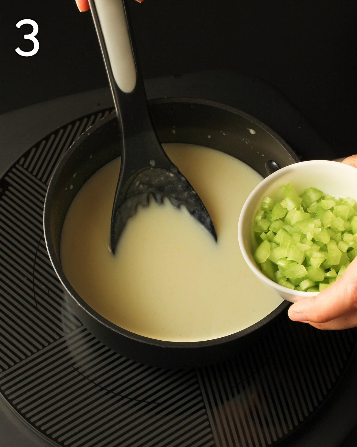 adding celery to the pot of soup in the pan.