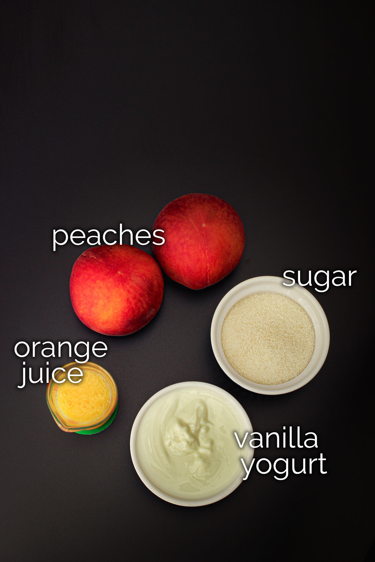 ingredients for peach yogurt popsicles on black table.