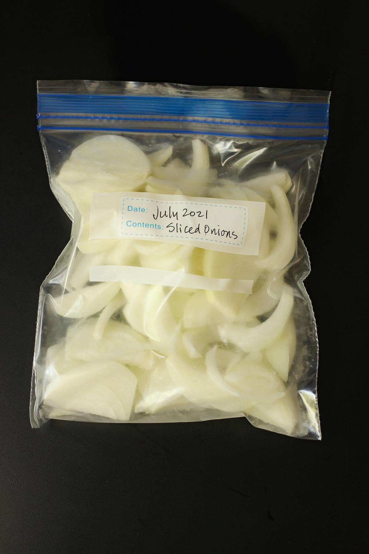 sliced onions in labeled ziptop freezer bag.