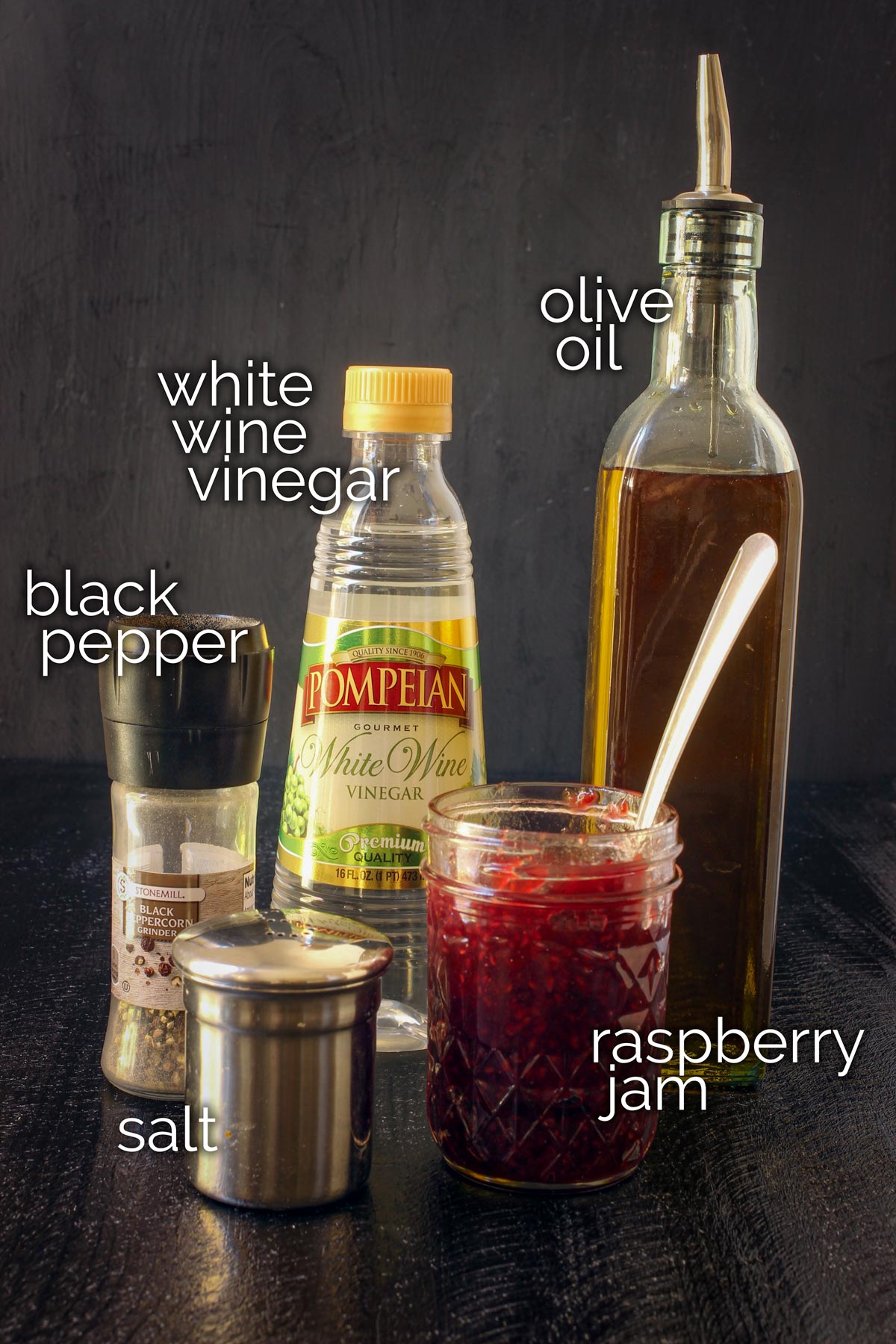 raspberry vinaigrette ingredients laid out on a black table top.