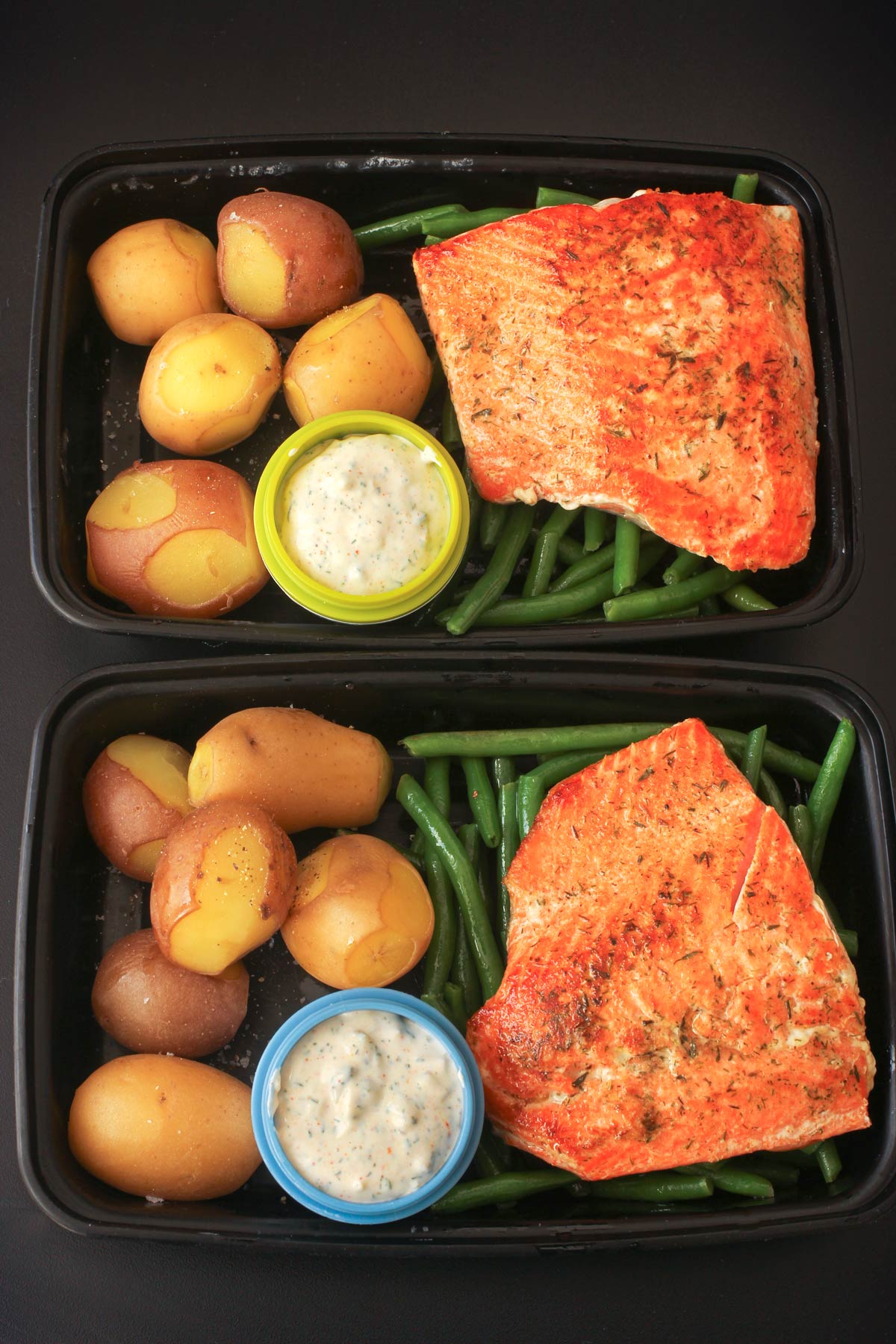 meal prep boxes with green beans, salmon, and potatoes with tartar sauce.