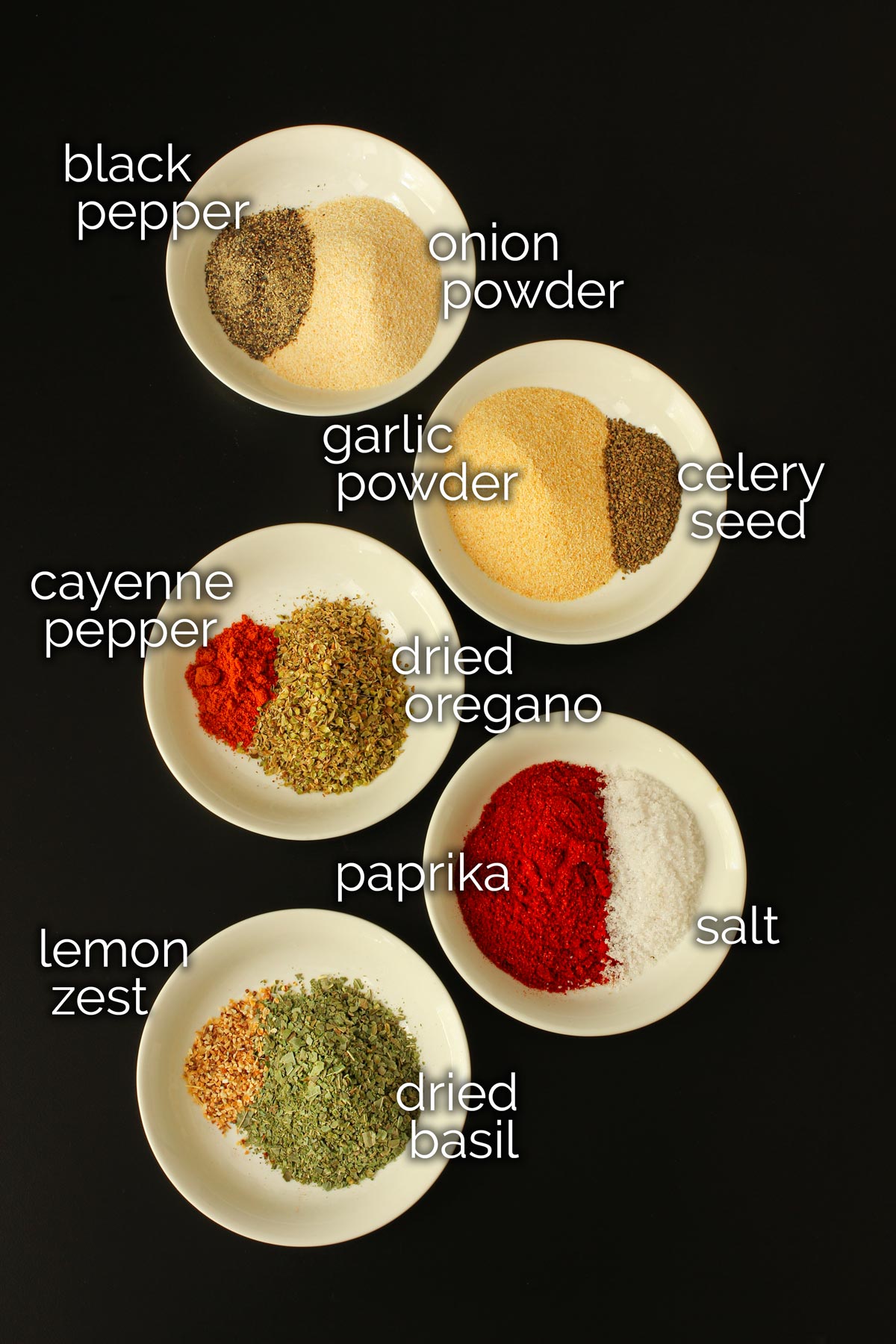 ingredients for jamie's spice mix in small white dishes on a black table top.