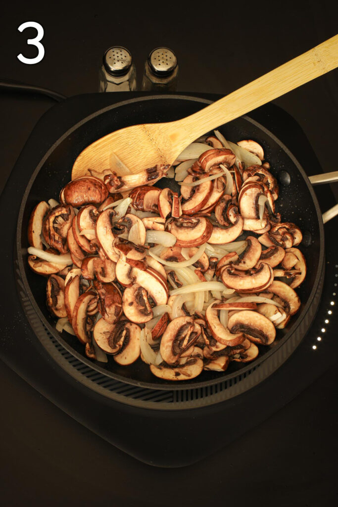 adding mushrooms to the onions in the skillet.