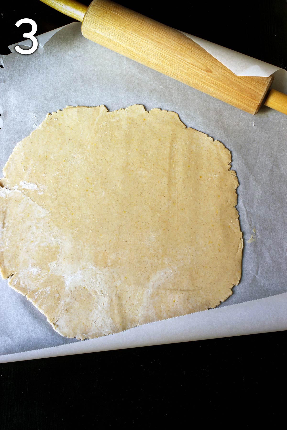 rolling out pastry on parchment paper.