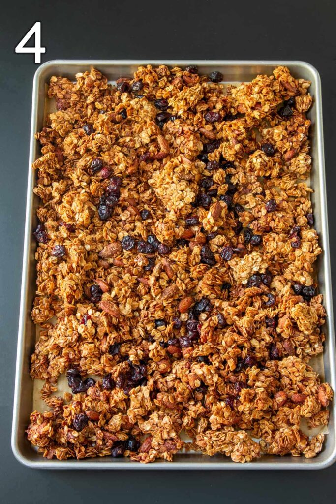 adding dry cranberries to baked granola.