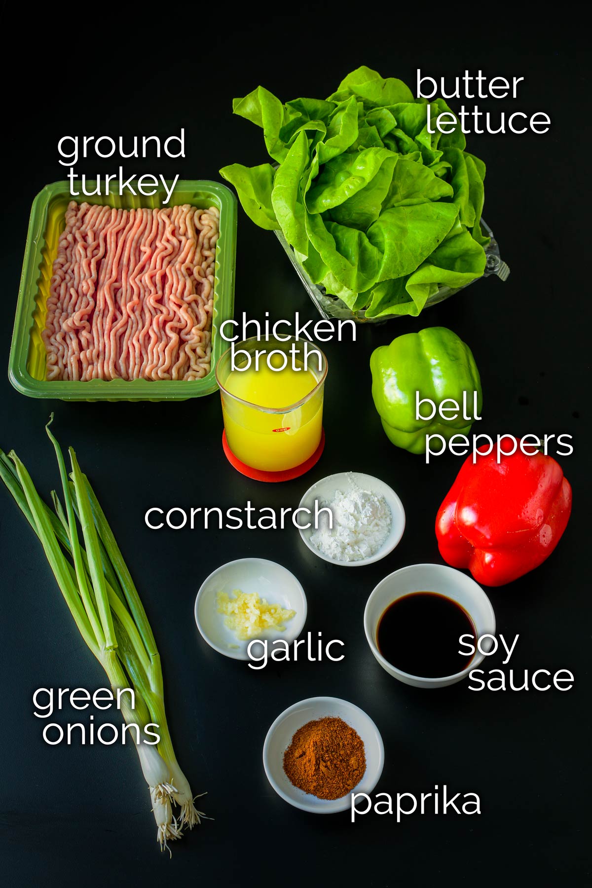 ingredients for turkey lettuce wraps laid out on a black table top.