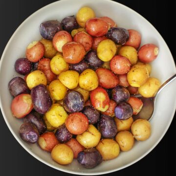 tri-color potatoes cooked and seasoned in a large white bowl.