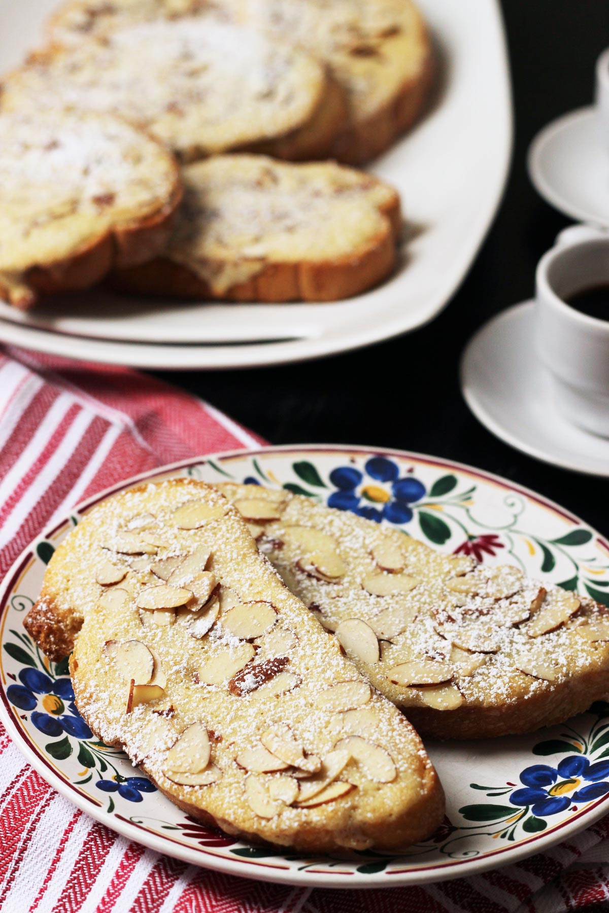 slices of bostock on a serving plate with espresso nearby.