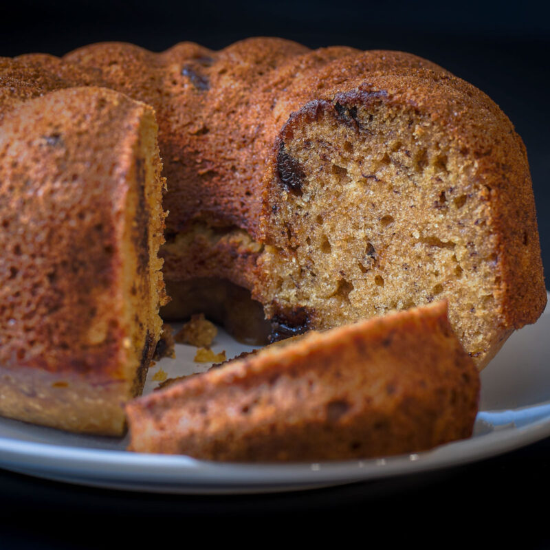 fluted banana bread on white platter, cut into slices.