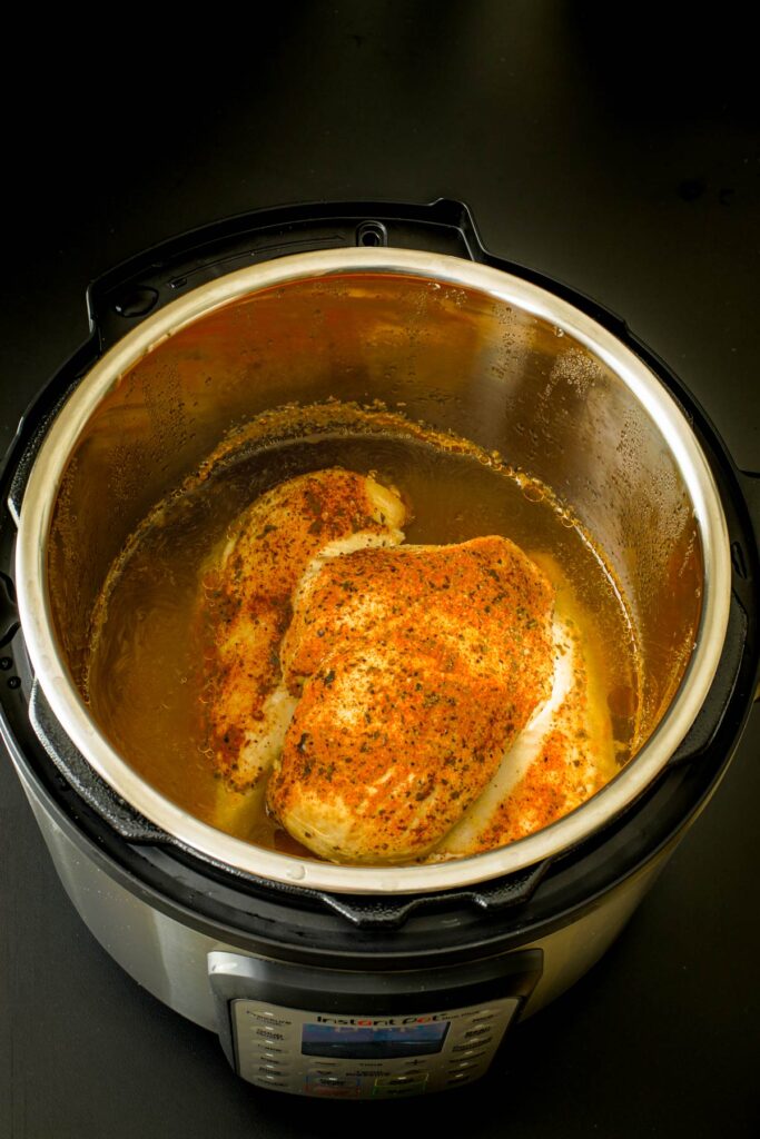 cooked chicken in broth in pressure cooker.