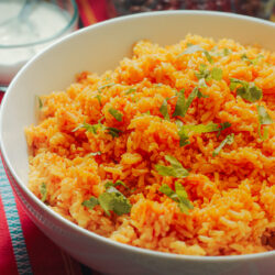 white bowl of mexican rice topped with chopped cilantro.