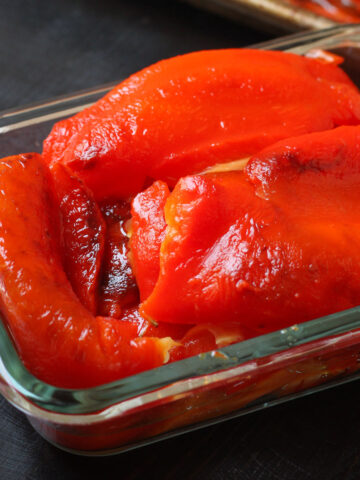 roasted red peppers in glass storage container.