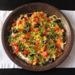 brown pie plate holding taco layer dip.