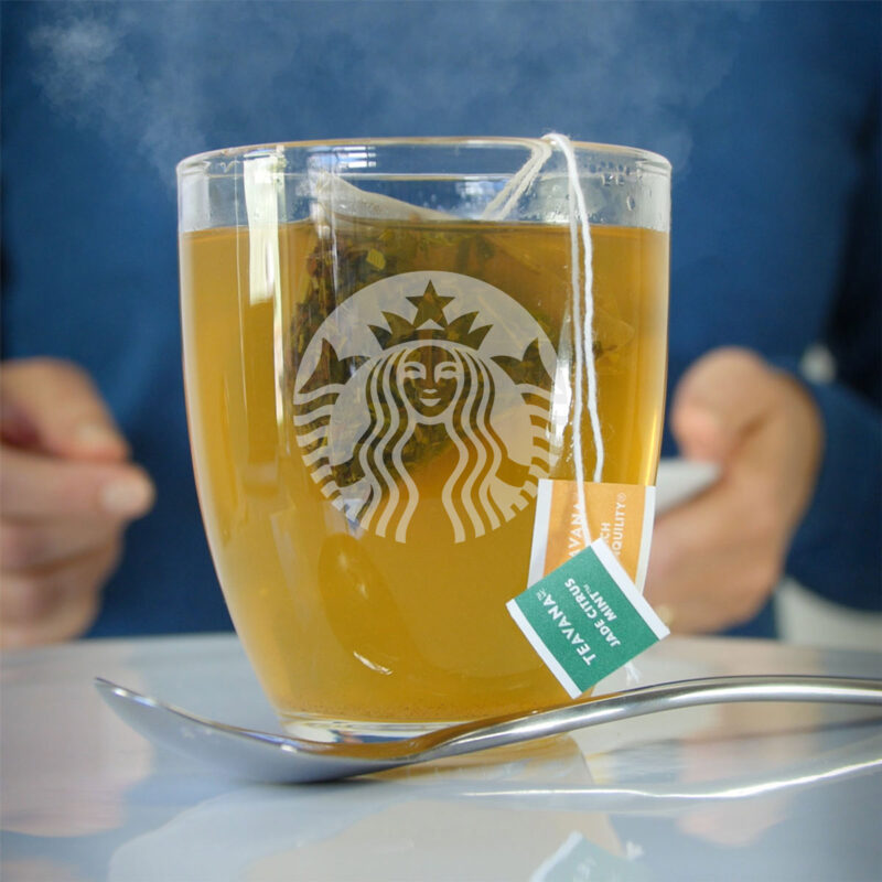 medicine ball tea in clear glass mug with starbucks logo.