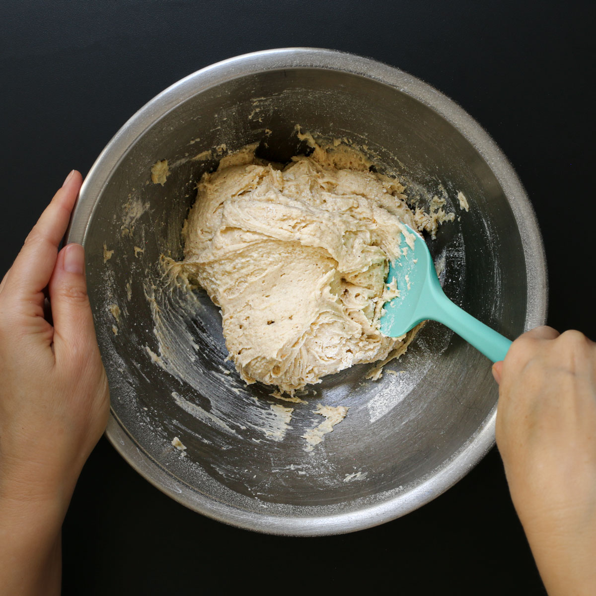 scraping the pear cake batter from the sides of the mixing bowl. 