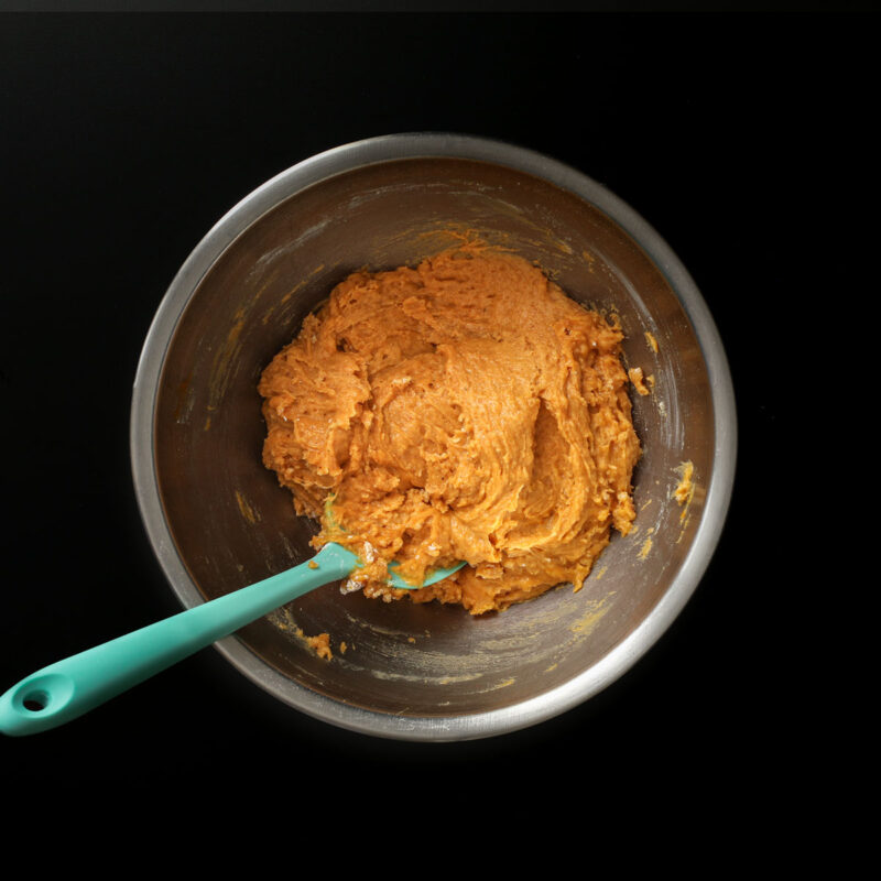 batter stirred together with teal spatula in mixing bowl.