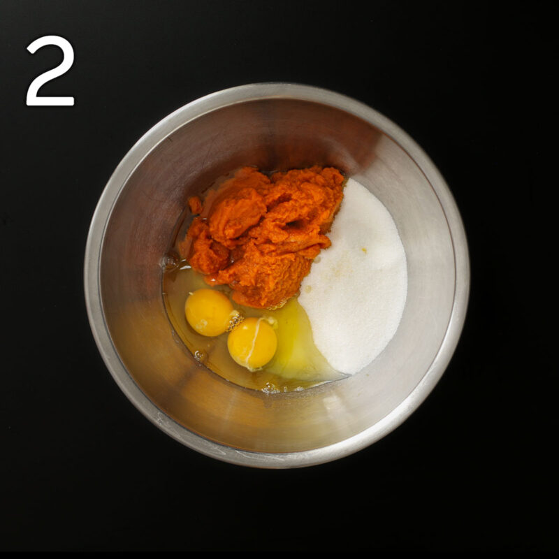 eggs, pumpkin, and sugar added to metal mixing bowl.