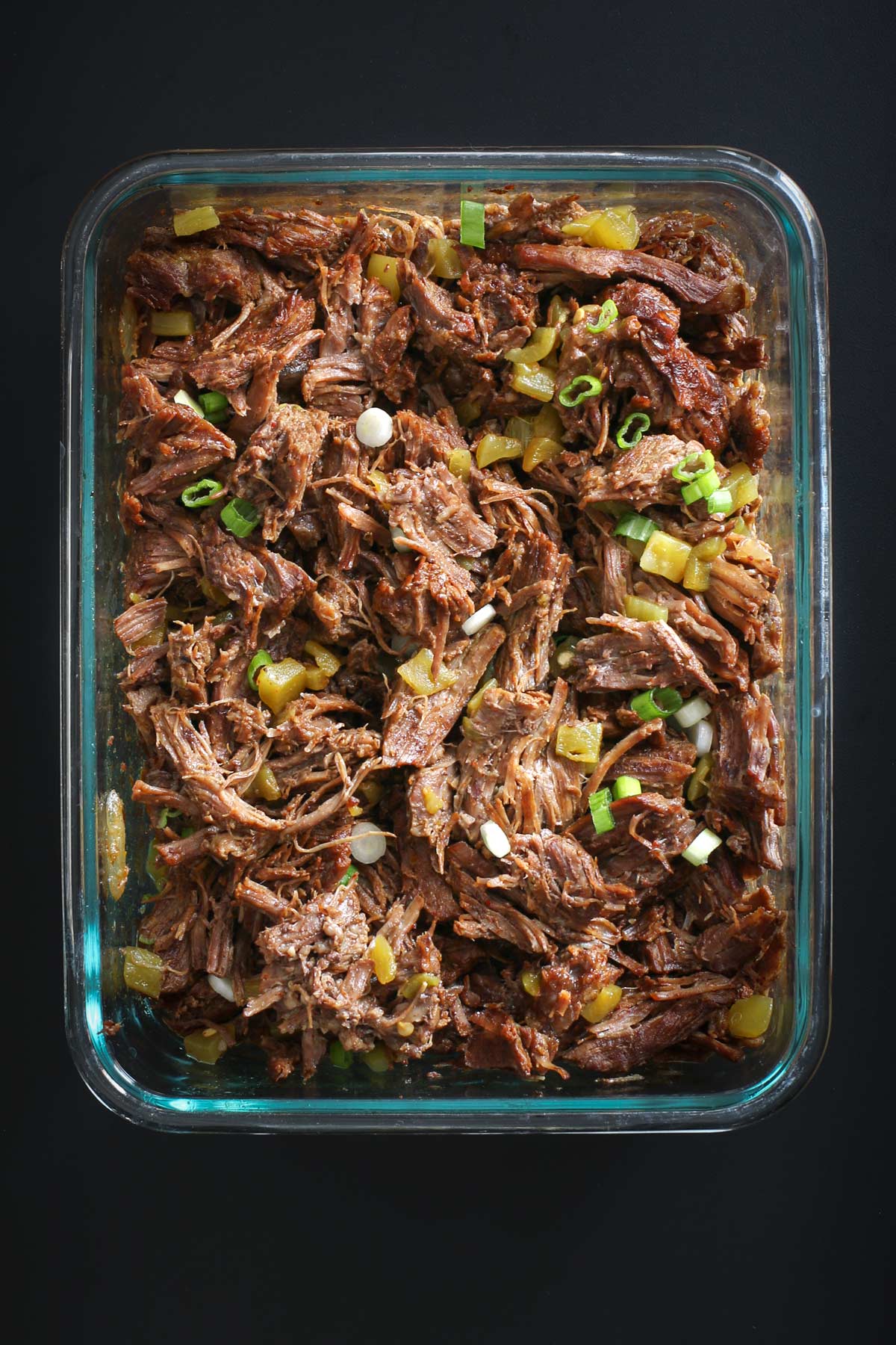 shredded beef in a glass storage container ready for freezing.
