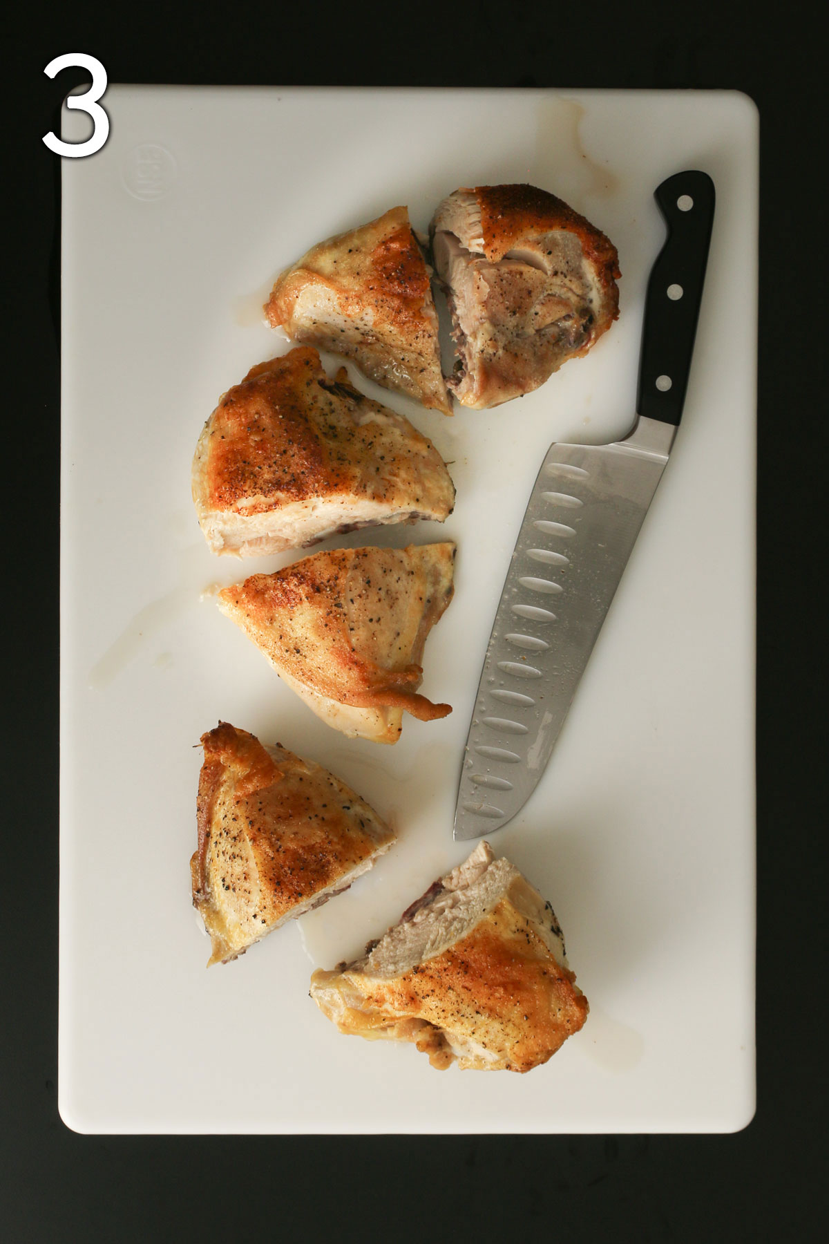 three chicken breast halves cut into half again on white cutting board with knife nearby.