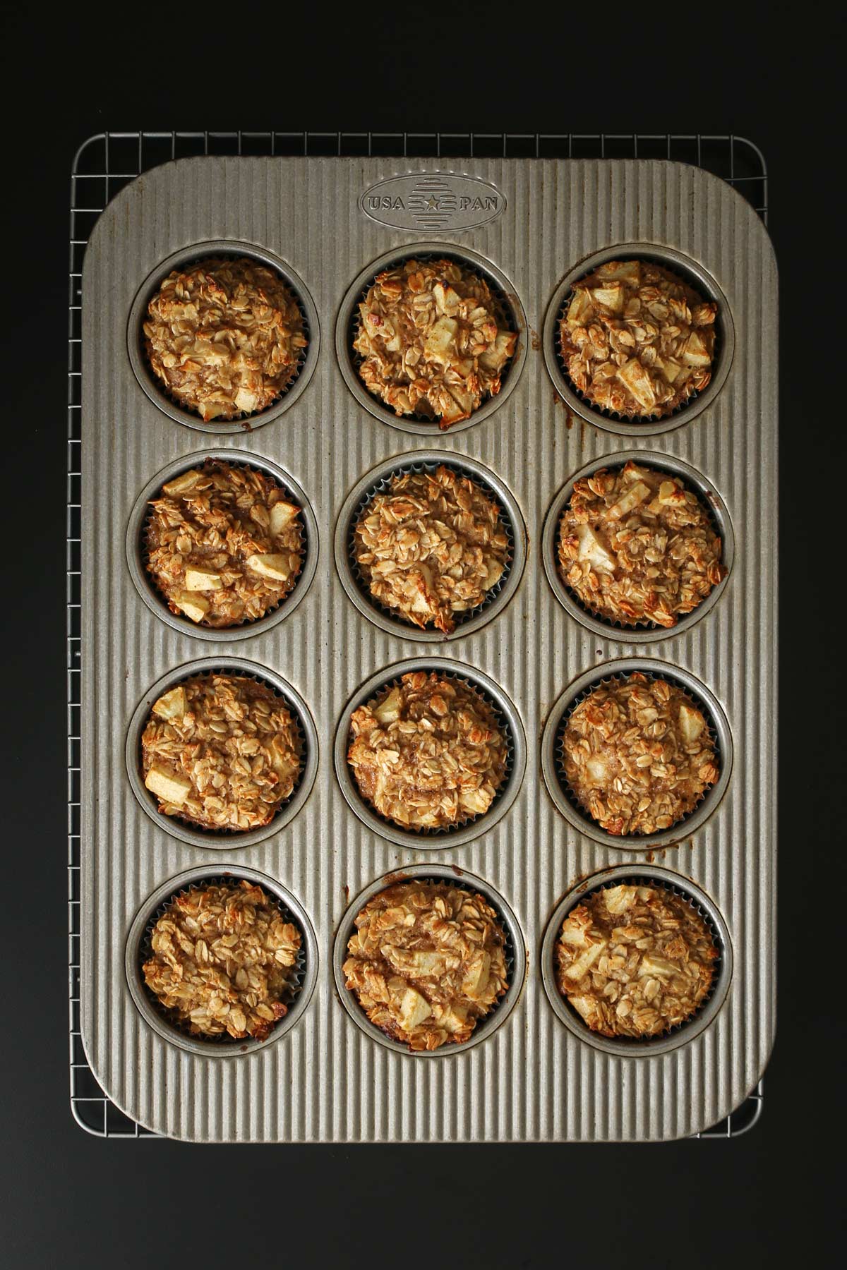 baked oatmeal cups in pan on wire rack on work surface.