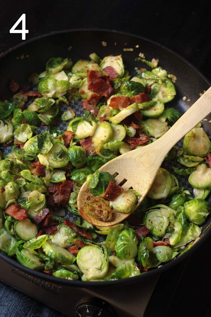 stirring the bacon into the sprouts with a wooden spoon.