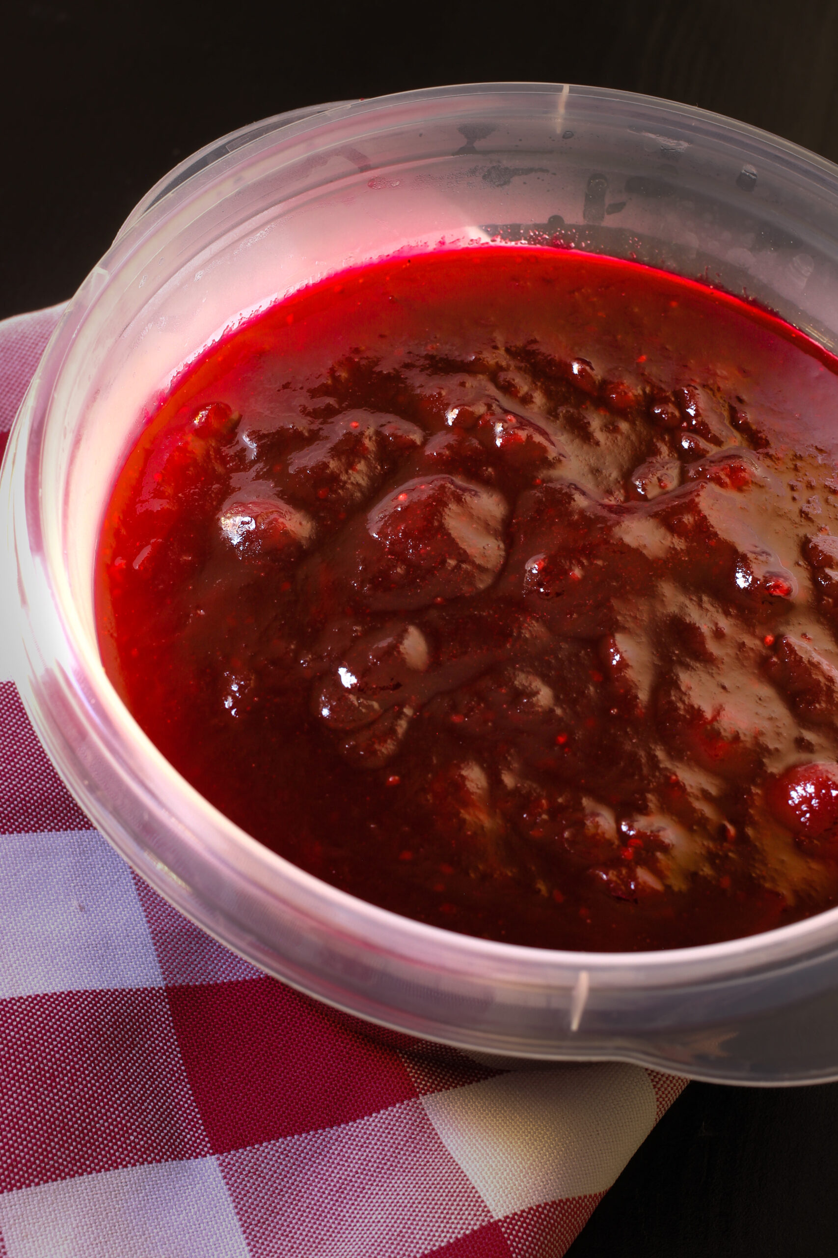 homemade cranberry sauce in a plastic dish to freeze.
