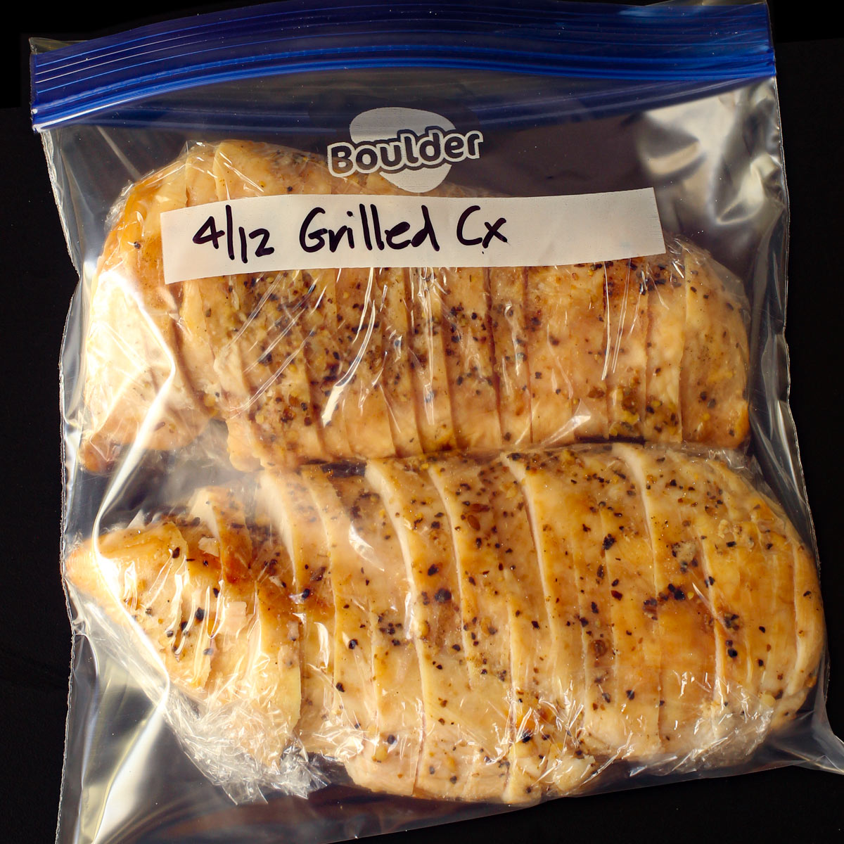 sliced grilled chicken breast wrapped and placed in ziptop bag.